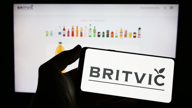 Stuttgart, Germany - 04-02-2023: Person holding cellphone with logo of British soft drinks company Britvic plc on screen in front of business webpage. Focus on phone display.