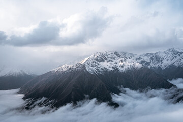 Alpine landscape with peaks covered with snow and clouds