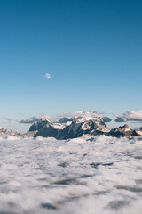 View of the moon and the Caucasian ridge with Mount Ushba above the clouds
