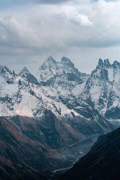 View of the valley and Mount Ushba and snow-covered peaks on a cloudy day