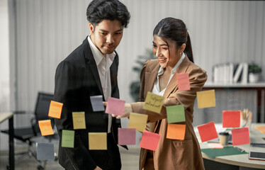 Businessperson discuss, exchange ideas and develop fresh perspectives by using sticky notes. Working collaboratively as a team help generate innovative ideas and potential solutions for the company.