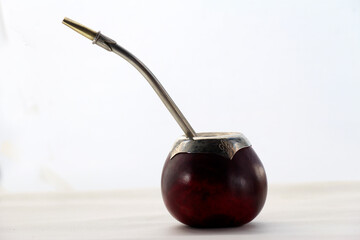 Traditional mate gourd cup made of natural calabash with intricate Alpaca metal details, accompanied by a metal straw or bombilla. Perfect for enjoying yerba mate.