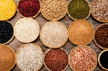 Collection of organic cereal and grain seed in dark tone on grunge wooden background for healthy or carbohydrate food ingredient and agricultural product concept