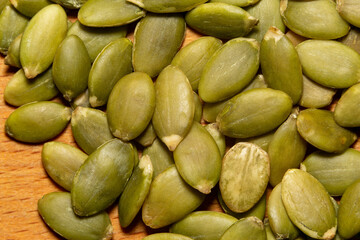 Macro background texture of green pumpkin seeds, extreme close-up view