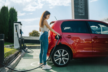 Woman charging electric car in station