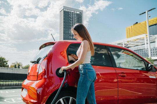 Woman charging electric car in station