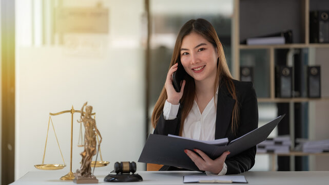 Asian female lawyer talking on the phone consulting with a client in a lawsuit.