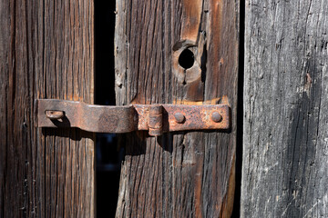 old unpainted wooden gate with rusty hardware