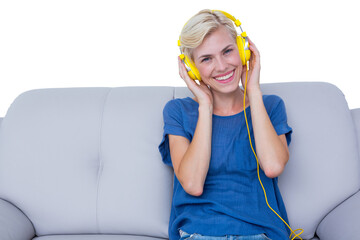 Happy woman listening music while sitting on couch
