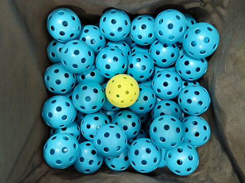 Blue and Yellow Pickleballs in a Basket