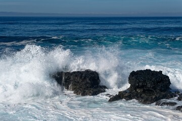 waves crashing on black rocks