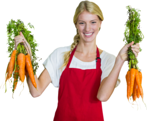 Portrait of smiling young woman holding carrots