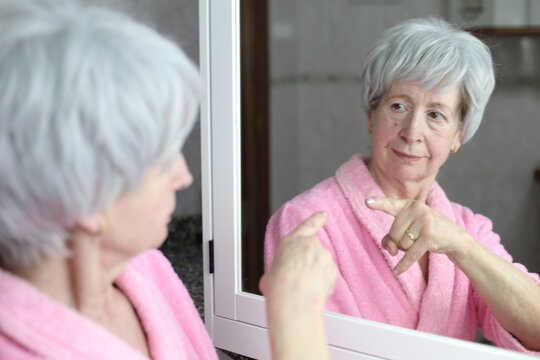 Senior woman pointing to her own reflection with pride 