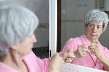 Senior woman ready to fight her mirror reflection 