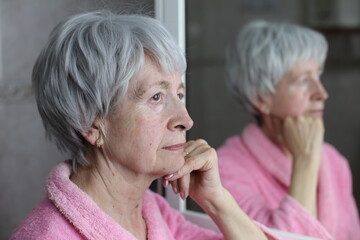 Profile of senior woman thinking with her own reflection 