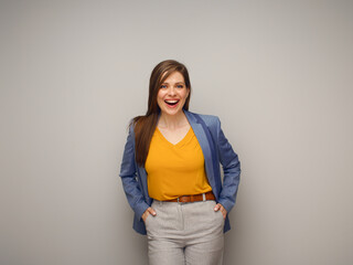 Portrait of excited smiling woman in blue suit and yellow shirt.