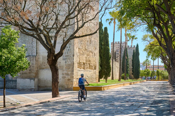 nice, active senior woman cycling with her electric mountain bike in downtownt of old moorish city of Jerez de la Frontera, home of Sherry vine, Andalusia, Spain
