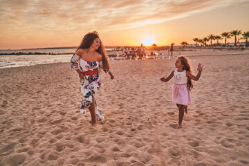 Mother and daughter playing and having fun on the beach
