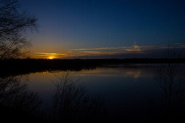 Dramatic and colorful sunset over a forest lake reflected in the water. Blakheide, Beerse, Belgium. High quality photo