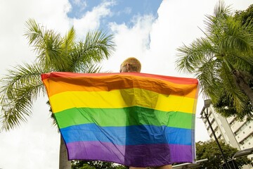 Back view of human holding LGBT flag