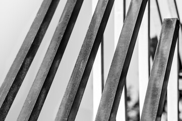 Several steel square pipes are arranged parallel to each other. Black and white photo