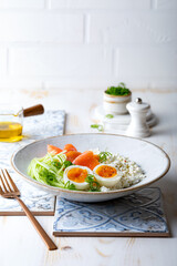 Fototapeta na wymiar Cottage cheese with smoked salmon, cucumber, soft boiled egg and fresh chives. Savory hight protein breakfast bowl.