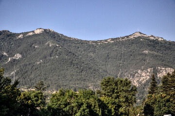 Die, France - August 10th 2022 : Two mountains surround the city of Die. The one with an antenna and a cross at its top, is the mountain of Justin. Its summit offers a superb panorama of Vercors.