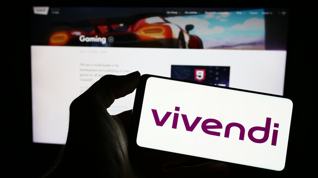 Stuttgart, Germany - 04-04-2023: Person holding smartphone with logo of French mass media company Vivendi SE on screen in front of website. Focus on phone display.