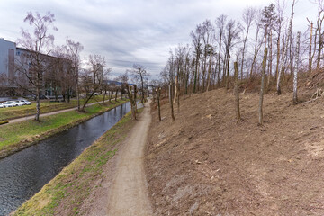 Fototapeta na wymiar Renaturation of Glatt River with cut trees at City of Zürich district Schwamendingen on a cloudy winter day. Photo taken February 17th, 2023, Zurich, Switzerland.