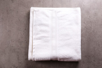 Top view of folded towels on concrete textured table. Minimalistic towel arrangement. Copy space for text, background, flat lay.