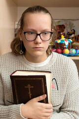 Portrait of a girl with a bible in her hands.