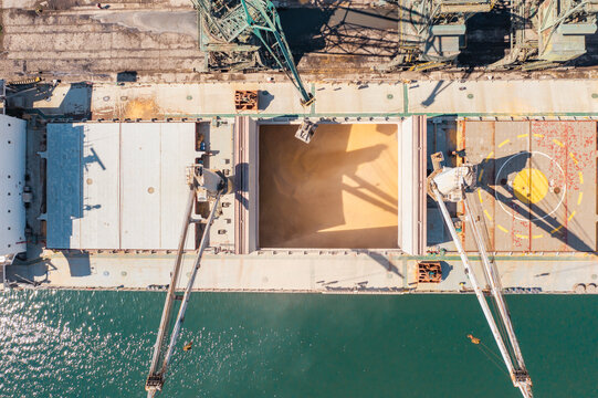 Aerial Top down view Black Sea port close up Loading of dry cargo ship by grain cranes. Maritime grain Import and export concept