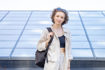 Beautiful young brunette woman 20 - 25 years old.  Student with a backpack.