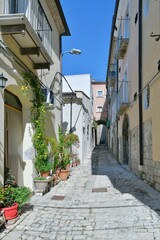 Fototapeta na wymiar A narrow street among the old houses of Larino, a medieval town in the province of Campobasso in Italy.