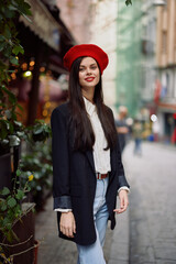 Woman smile fashion model walks on the street in the city center among the crowd in a jacket and red beret and jeans, cinematic french fashion style clothing, travel to istanbul spring