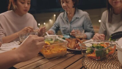 Enjoy eat yummy thai food with rice curry and drink at dine table outdoor house night party with mum. Asia older people mom and young adult child smile relax meet happy picnic meal warm time talk fun.