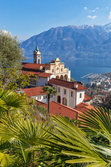 Early spring in Locarno, Ticino, Switzerland. View to Madonna del Sasso church and Lago Maggiore. - 592323268