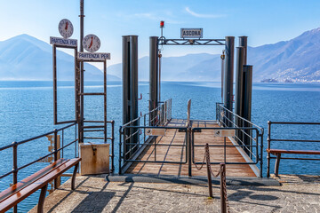 Fototapeta na wymiar Pier in Ascona on Lago Maggiore in Switzerland. Information tables read in Italian: 