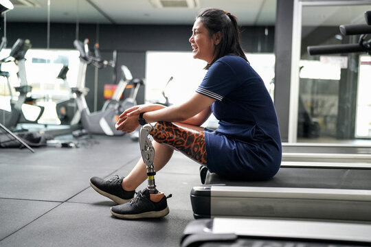 Portrait of disabled athlete woman with prosthetic leg in fitness. Closeup on bionic prosthetic leg.