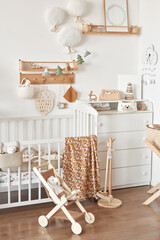 Fototapeta na wymiar Children's educational wooden toys. Nursery decor. Scandinavian style playroom. Wooden stroller. Crib