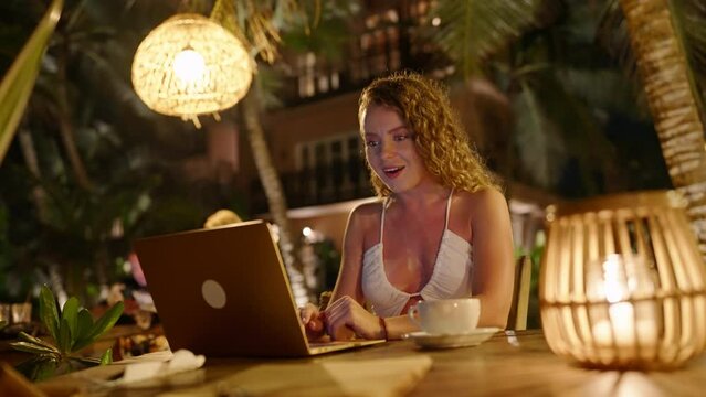 Surprised young woman looking at laptop screen smiling. Portrait of happy girl shopping online finds something cool. Close-up of excited caucasian female watching great positive news at computer.