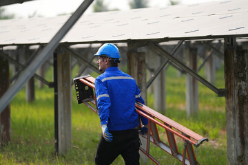 Naklejka na ściany i meble Electrician engineer with white helmet working at a photovoltaic farm, checking and maintenance equipment with instruments at industry solar power.