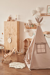 Children educational wooden toys. Nursery decor. Playroom. Wooden stroller, table, chair. Wigwam