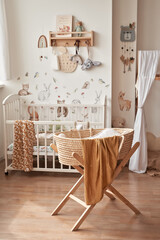 Fototapeta na wymiar Children's educational wooden toys. Nursery decor. Scandinavian style playroom. Wicker cradle