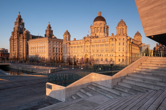 Evening light illuminates the Liver Building, the Cunard Building and Port of Liverpool Building (The Three Graces), Pier Head, Liverpool Waterfront, Liverpool, Merseyside