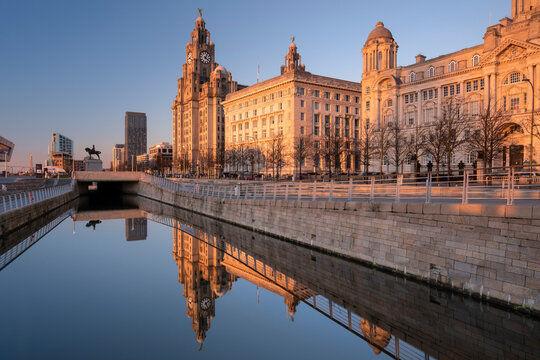 Evening light illuminates the Liver Building, the Cunard Building and Port of Liverpool Building (The Three Graces), Pier Head, Liverpool Waterfront, Liverpool, Merseyside