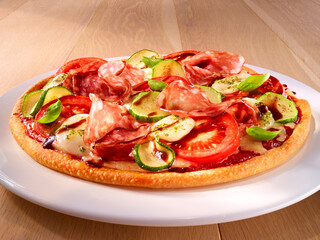 Reich belegte Pizza mit Salami Tomaten und Zucchini