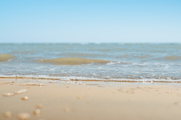 Closeup of sand on beach and blue summer sky. Panoramic beach landscape. Empty tropical beach and seascape.