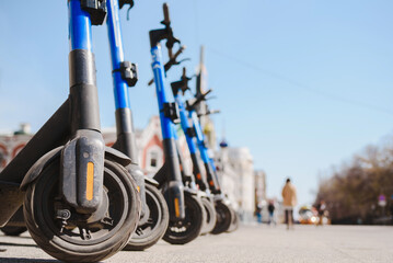 Electric scooters are parked in the city center. Modern public mobile transport