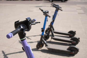 Electric scooters are parked in the city center. Modern public mobile transport
